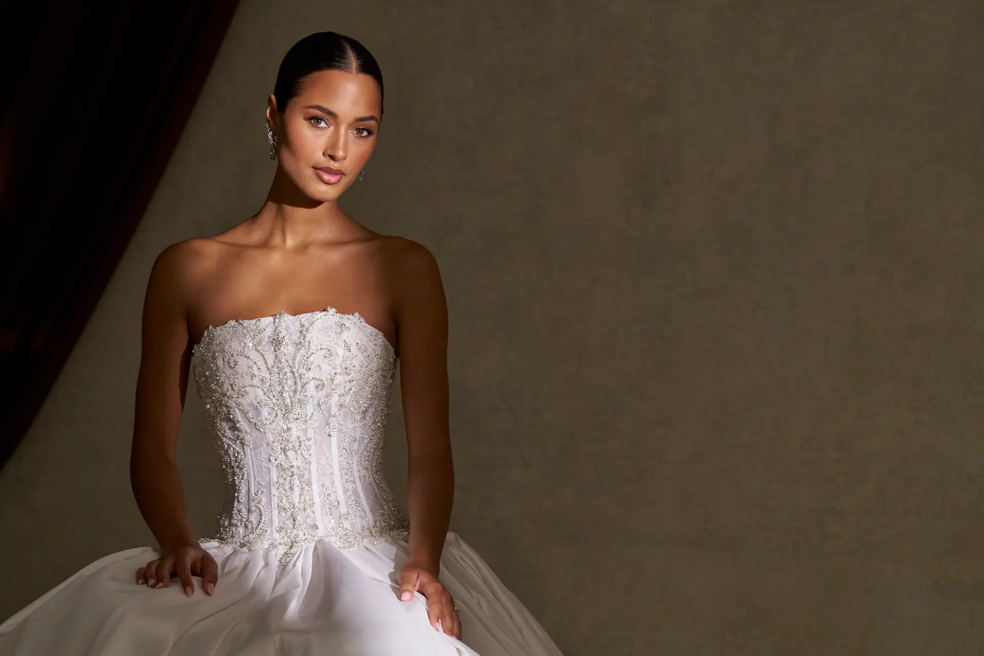 Model wearing the Allure Bridals C840 wedding dress with an embellished strapless corset bodice, drop waist and voluminous ball gown skirt, available at The Bridal Collection in Denver, Colorado.