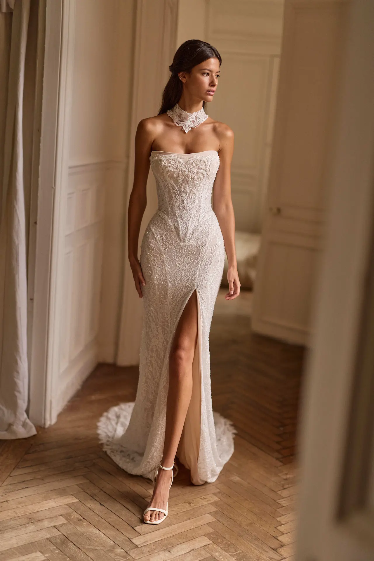 Milla Nova Bravelle fitted lace and beaded wedding dress. Basque waist, leg slit, strapless neckline.