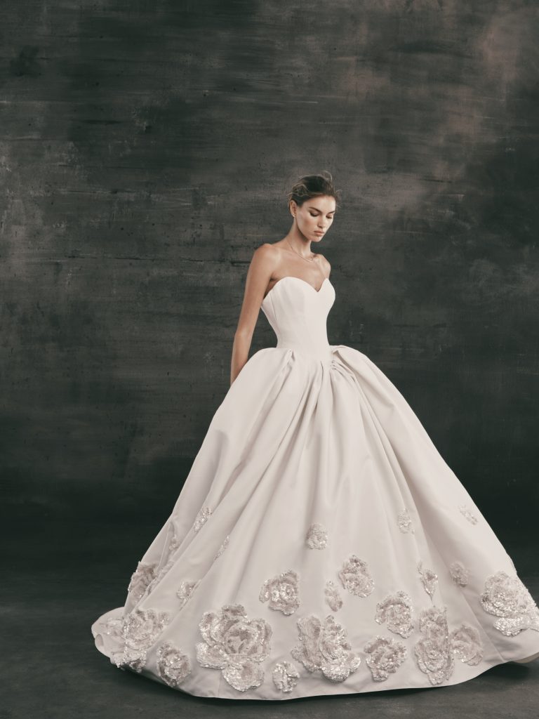 Nicole and Felicia strapless sweetheart ballgown wedding dress with structured satin bodice and large 3D sequin rose embellishments on the skirt hem.