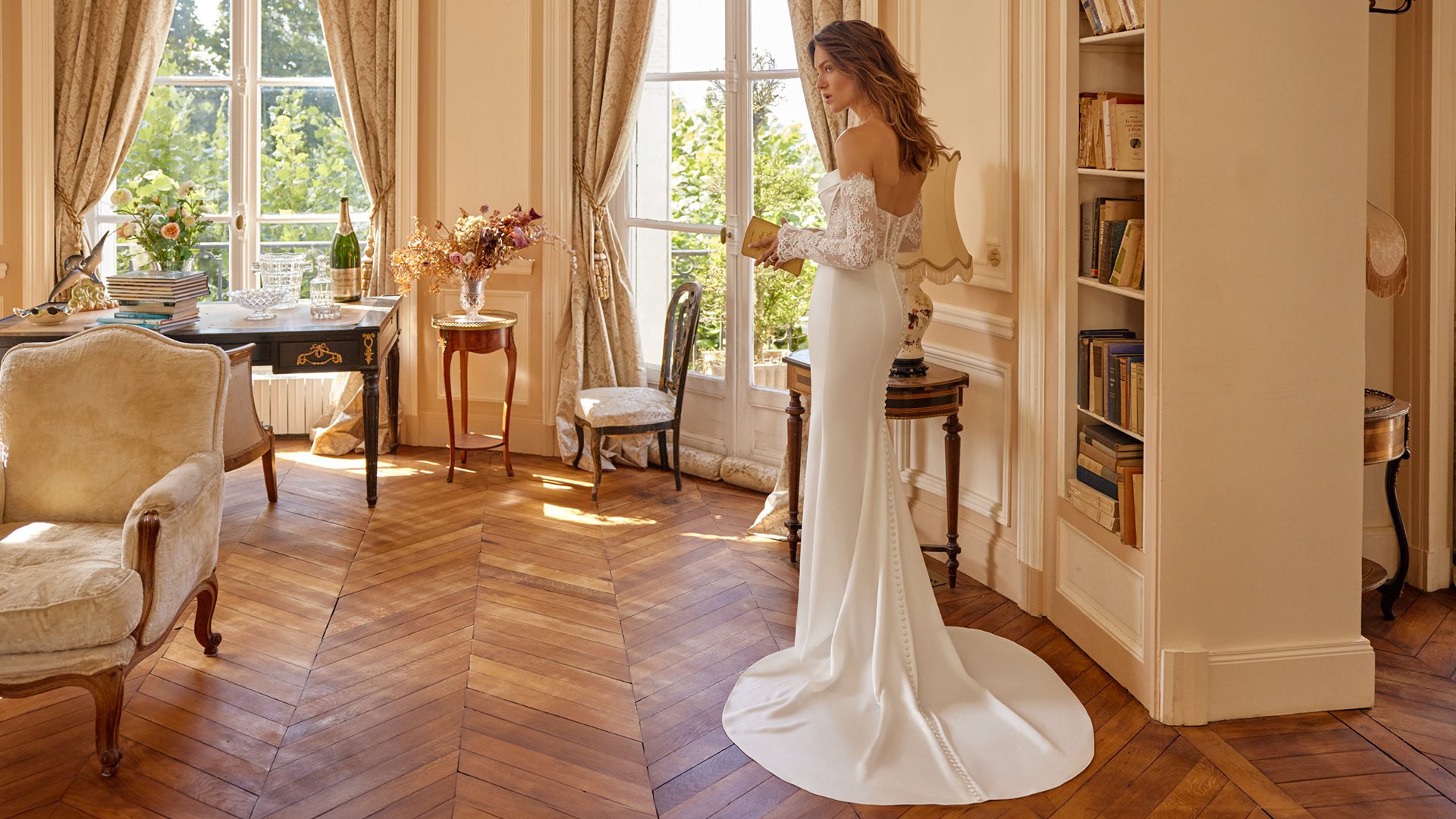 Model wearing the Justin Alexander Magdalena wedding dress with a strapless lace bodice and dramatic ruffled ball gown skirt with a sweeping train.